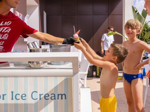 Des enfants prennent une glace à un stand par une journée ensoleillée.
