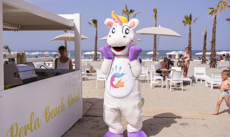 Strand mit Einhorn-Maskottchen in der Nähe des Kiosks.