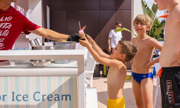 Des enfants prennent une glace à un stand par une journée ensoleillée.