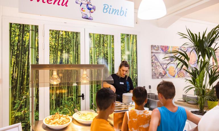 Buffet per bambini con piatti di pasta.