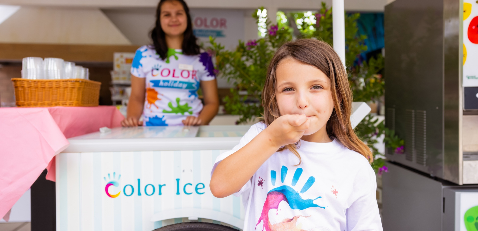 Bambina felice mangia gelato colorato, estate e gioia.