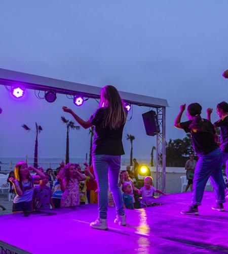 Festa con un costume da unicorno, circondato da bambini felici e sorridenti.