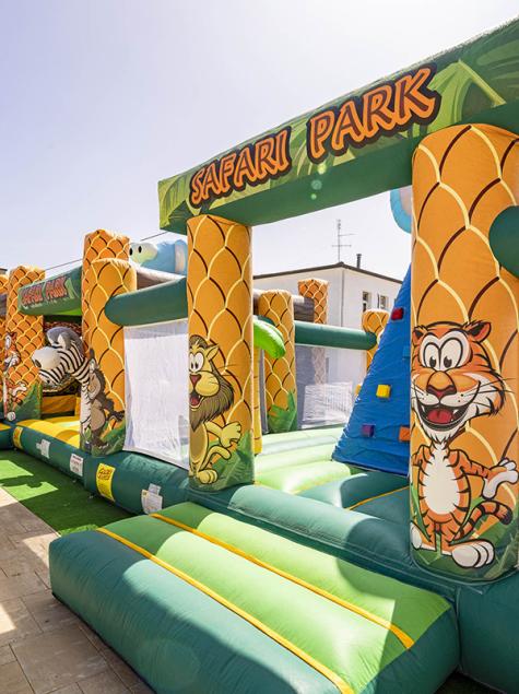 Buntes Safari Park Hüpfburg in der Nähe eines Pools, spielerische und spaßige Atmosphäre.