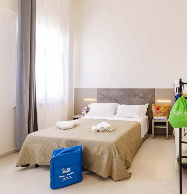 Gemütliches Zimmer mit Doppelbett und Etagenbetten, warme und helle Atmosphäre.