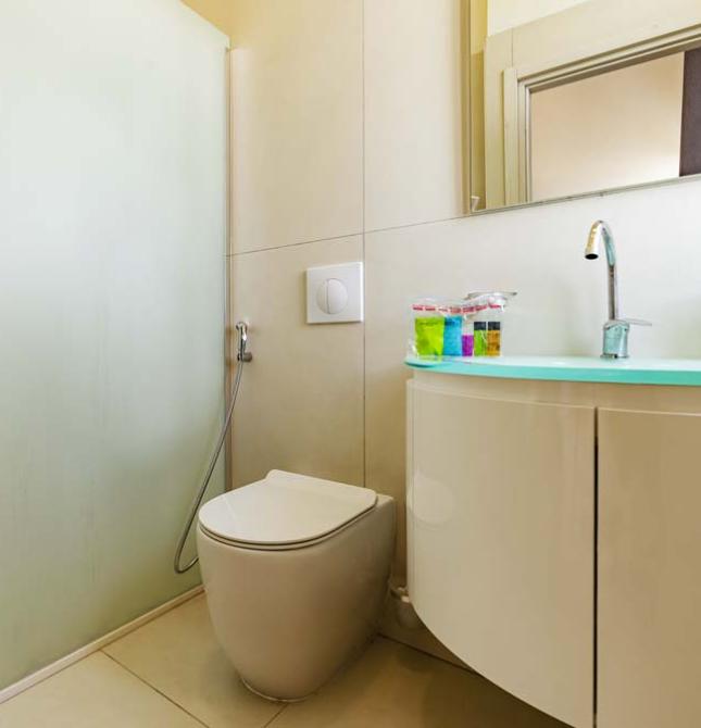 Modernes, minimalistisches, helles Bad mit eleganter Dusche und Waschbecken.