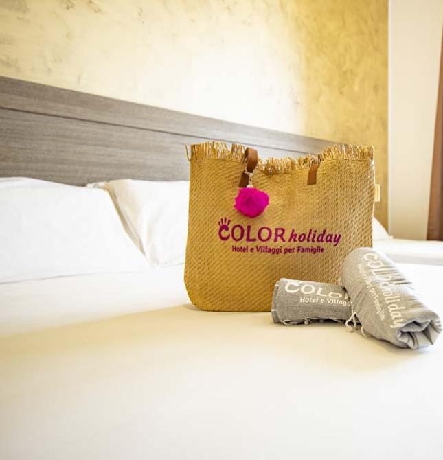 Helles Zimmer mit Tasche und Handtüchern auf gemütlichem Bett.