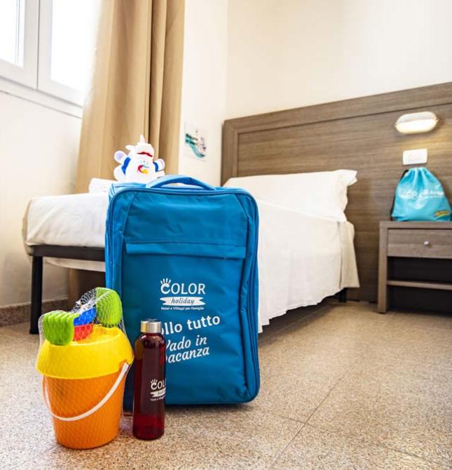 Blauer Koffer auf dem Boden, Urlaubs- und Entspannungsstimmung im hellen Zimmer.